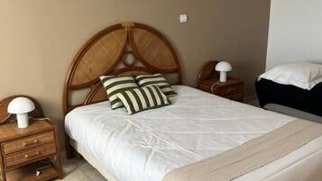 A bedroom with a single bed, two bedside tables, and a headboard.