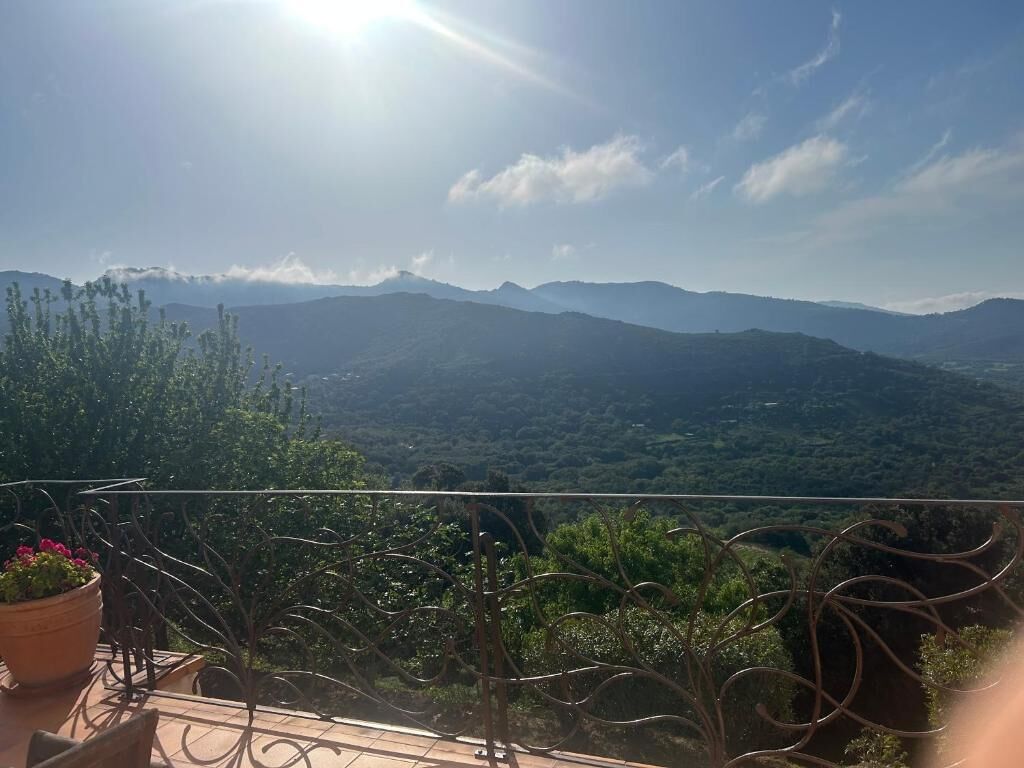 Een balkon met uitzicht op een bergachtig landschap.