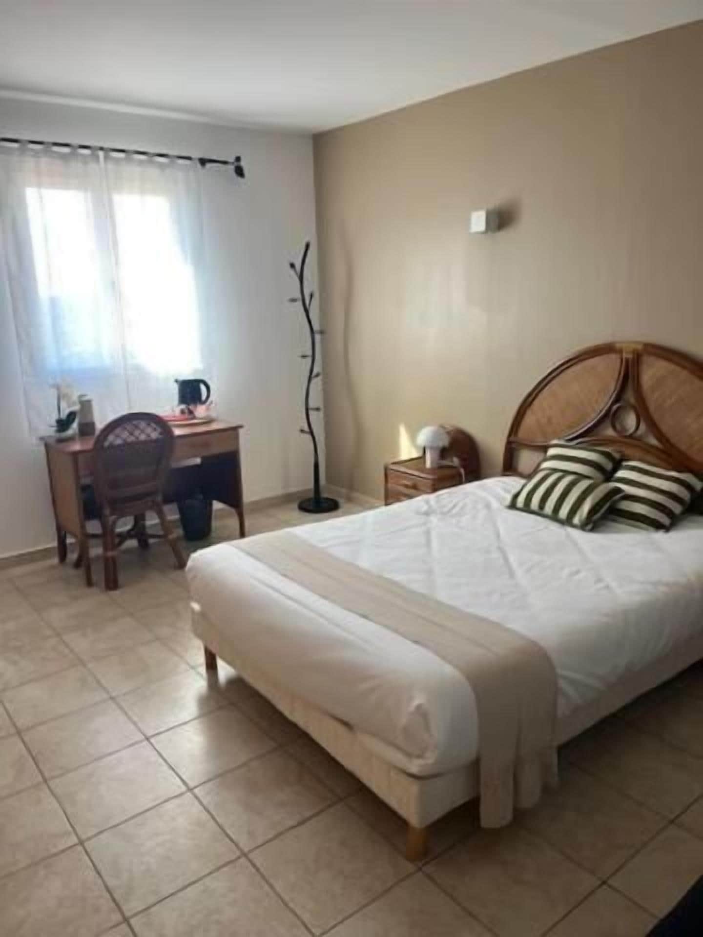 Un dormitorio con cama, escritorio y silla.