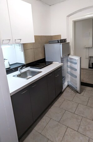 A kitchen with a sink, stove, cabinets, and a refrigerator. - Tiergarten: Spacious 2-Bedroom Designer Apartment Near the Park (Berlin)