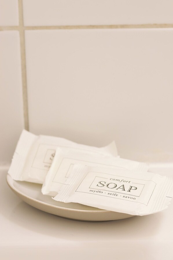 En tallerken med flere hvide sæbebarer mærket 'comfort SOAP' og 'mydlo . seife . savon'.