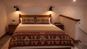 Ein Schlafzimmer mit einem Bett, zwei Nachttischen, einer Wandlampe und einem Holz-Kopfteil.