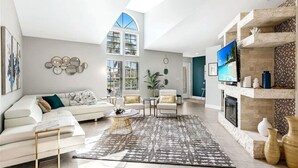A modern living room with a white sofa, armchairs, a coffee table, and a fireplace. - Cape Coral Pool Home Near Tarpon Point (Cape Coral)