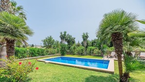 A rectangular swimming pool surrounded by grass and palm trees. - 2-Bed Villa with Pool, Puerto Pollença (Port de Pollença)