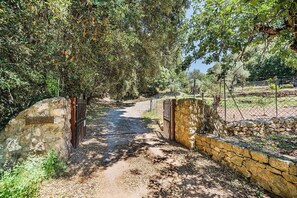 A pathway leading through a natural area with stone walls and a metal gate. - Mountain Villa with Large Pool (Pollensa / Pollença)
