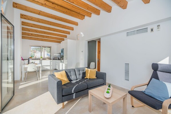 A modern living room with a grey sofa, a wooden coffee table, and a blue armchair.