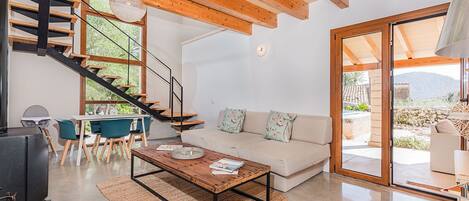 Un salon moderne avec un canapé, une table basse et un escalier.