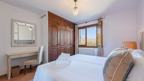 A bedroom with a bed, a desk, a chair, and a window with a view. - Elegant Villa witj Heated Pool, Pollença (Pollensa / Pollença)
