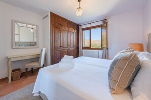 A bedroom with a bed, a desk, a chair, and a window with a view. - Elegant Villa witj Heated Pool, Pollença (Pollensa / Pollença)
