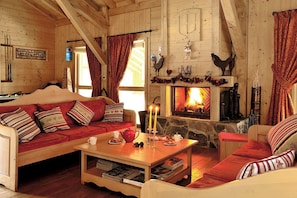 Ein gemütliches Blockhaus-Interieur mit Kamin, Holzmöbeln und einem Kamin aus Stein.
