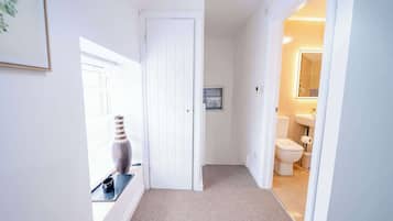 A hallway with a door leading to a bathroom.
