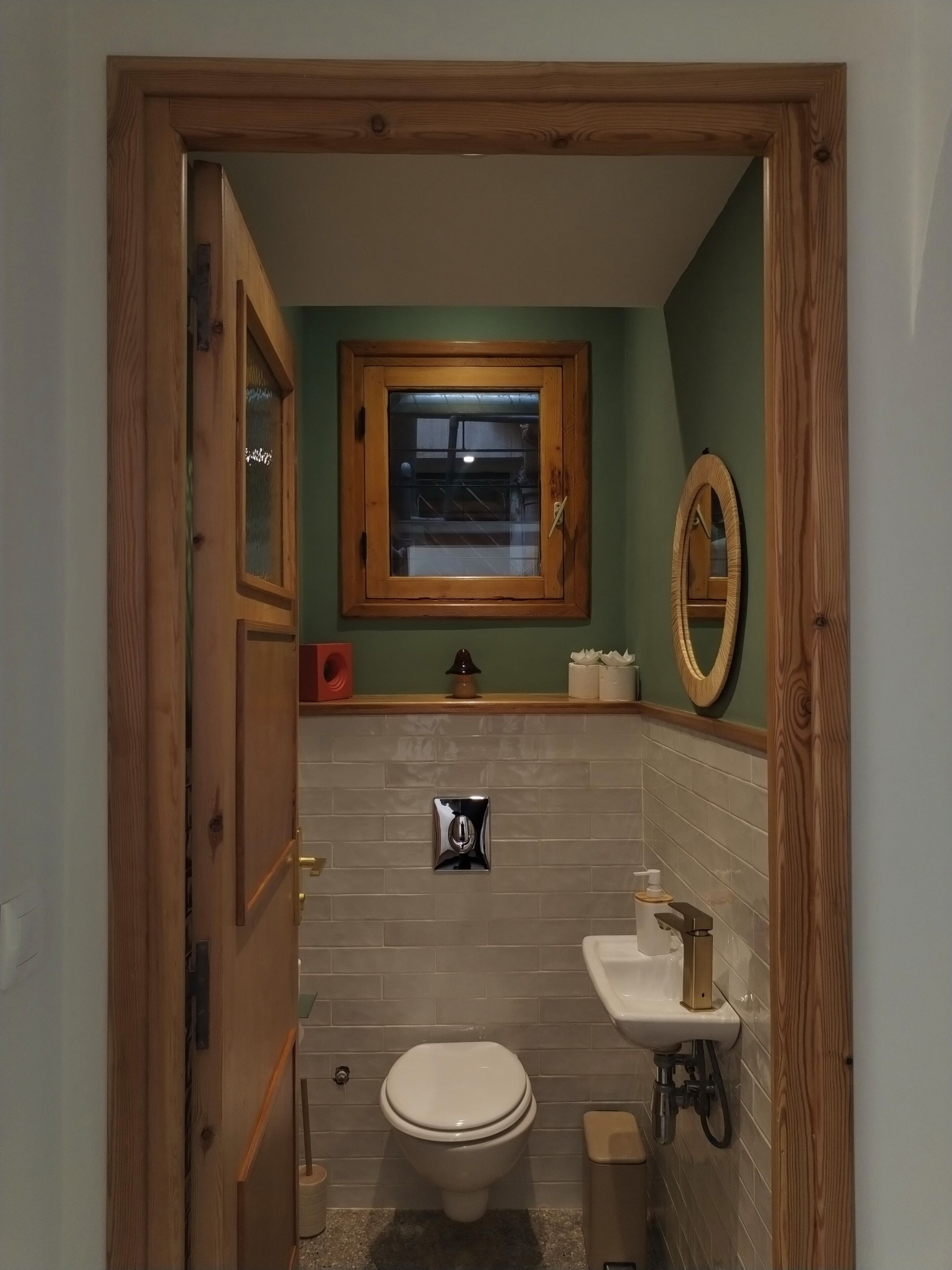 A bathroom with a toilet, sink, and mirror.