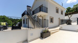 Un edificio a due piani con un balcone, una scala e una pianta in vaso.