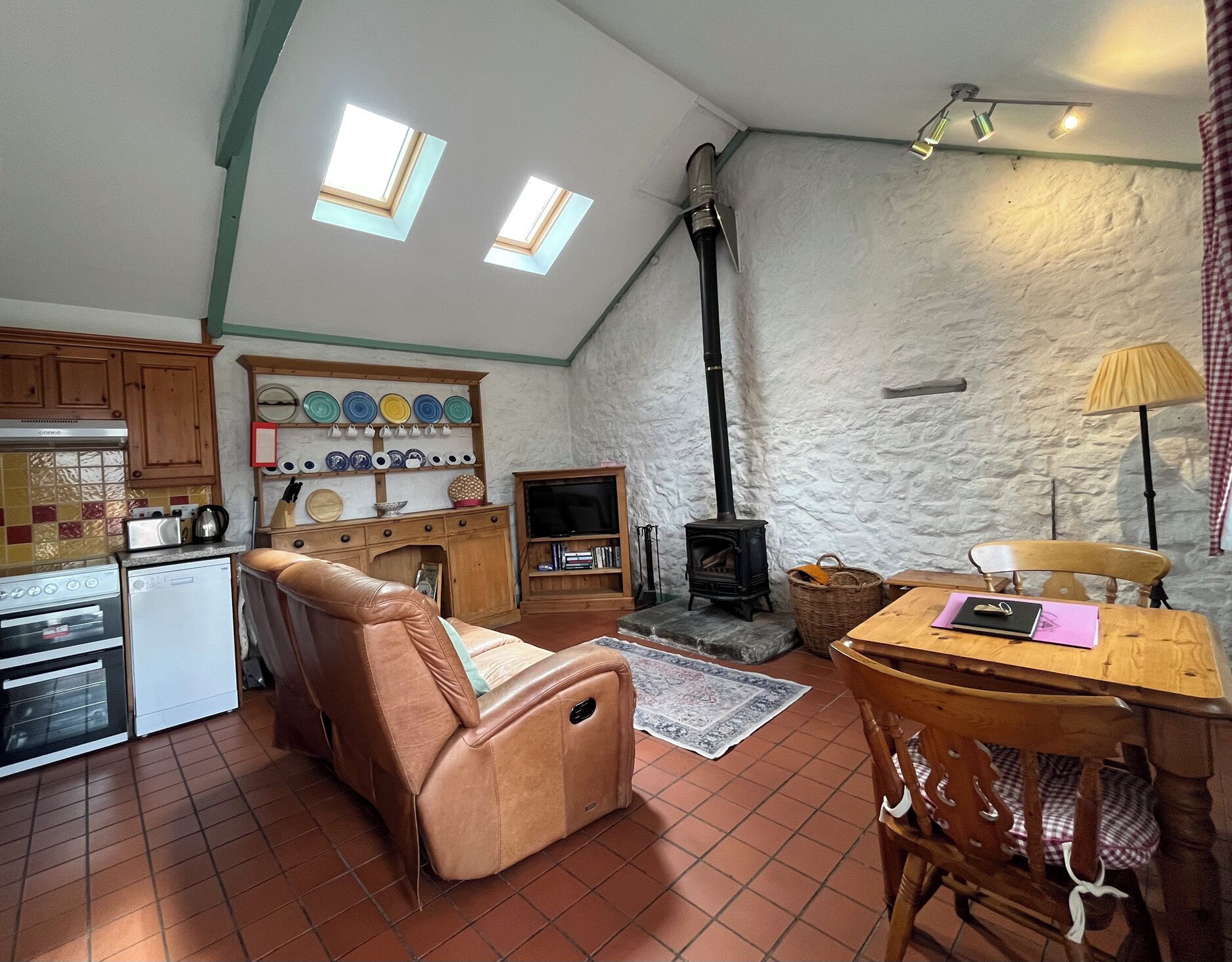A cozy living space with a kitchen, a fireplace, and a dining area.