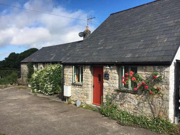 A stone building with a red door, a satellite dish, and a sign indicating 'Sullivan's 2'.