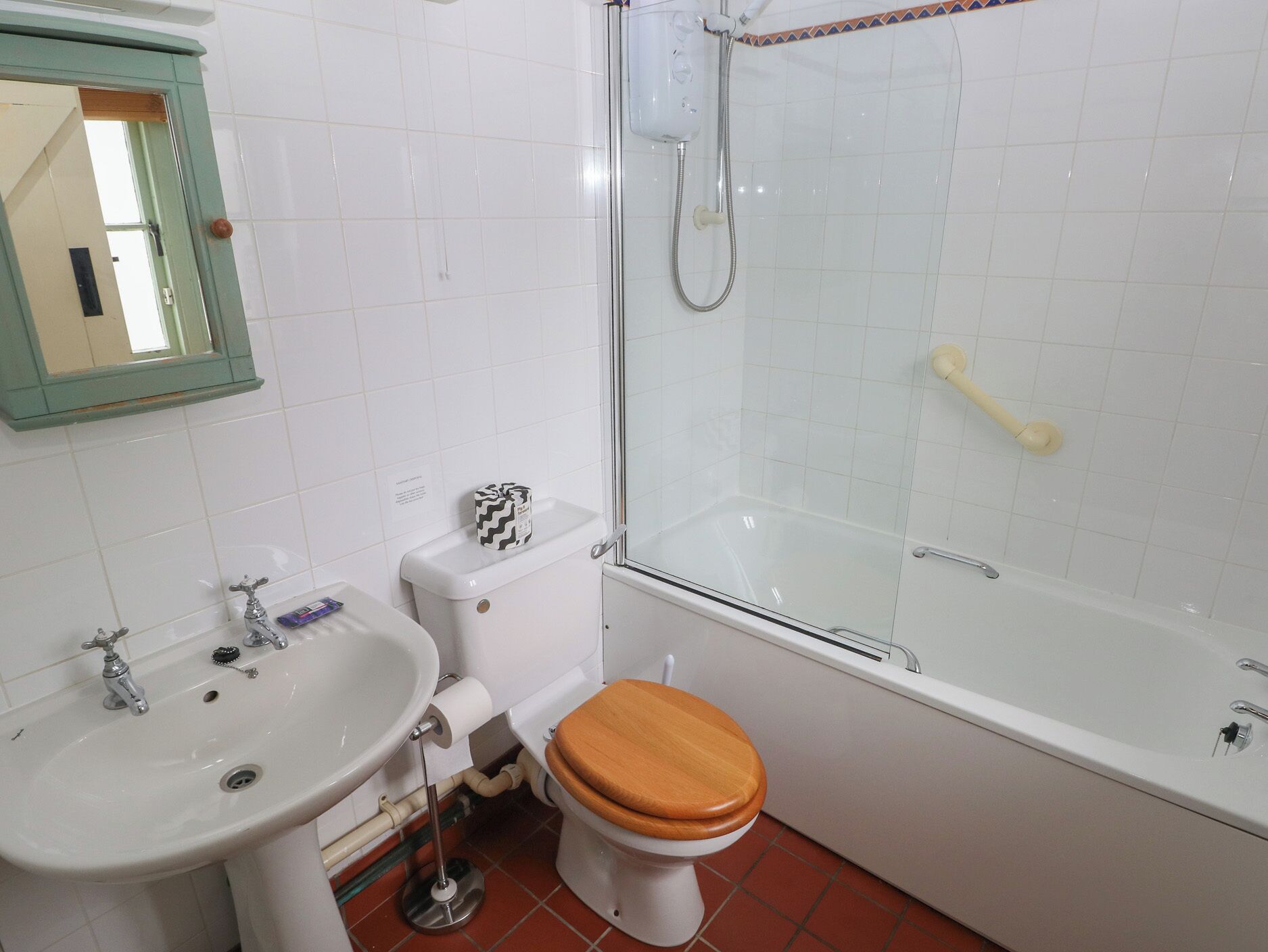 Une salle de bain avec un lavabo, des toilettes et une douche.
