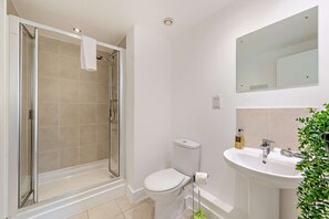 A bathroom with a glass-enclosed shower, a toilet, a sink, and a mirror. - Host & Stay | Kings View (Liverpool)