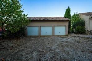 A building with a tiled roof and three garage doors.