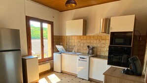 Een kleine keuken met een koelkast, spoelbak, vaatwasser en oven.