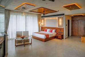 A modern hotel room with a large bed, a desk, and a seating area. - Mountree Munnar by Kondody Hotels (Devikolam)