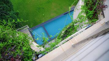 A swimming pool with a clear view of the surrounding grassy area and a building structure.
