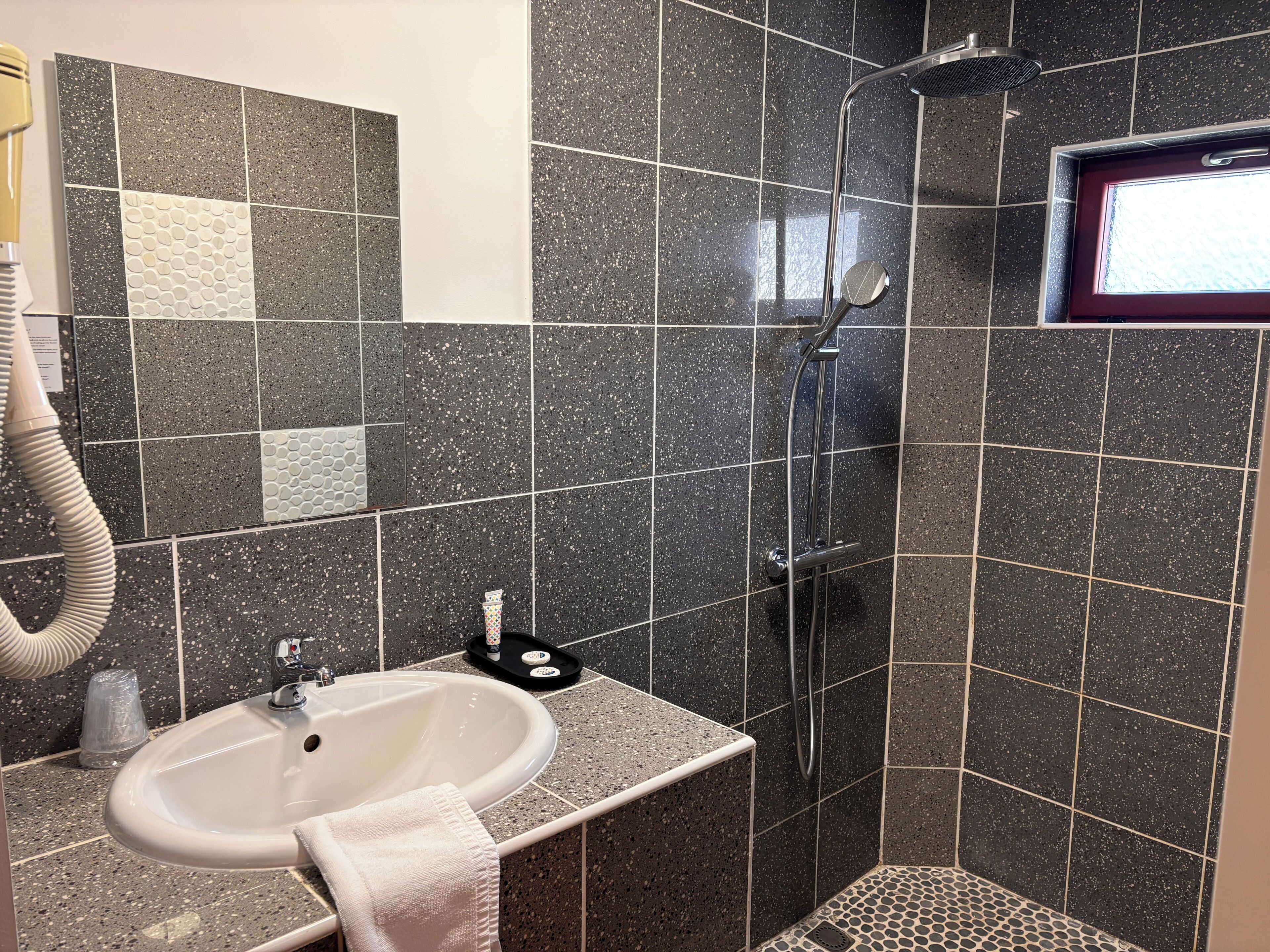 Un baño con lavamanos, espejo y ducha.