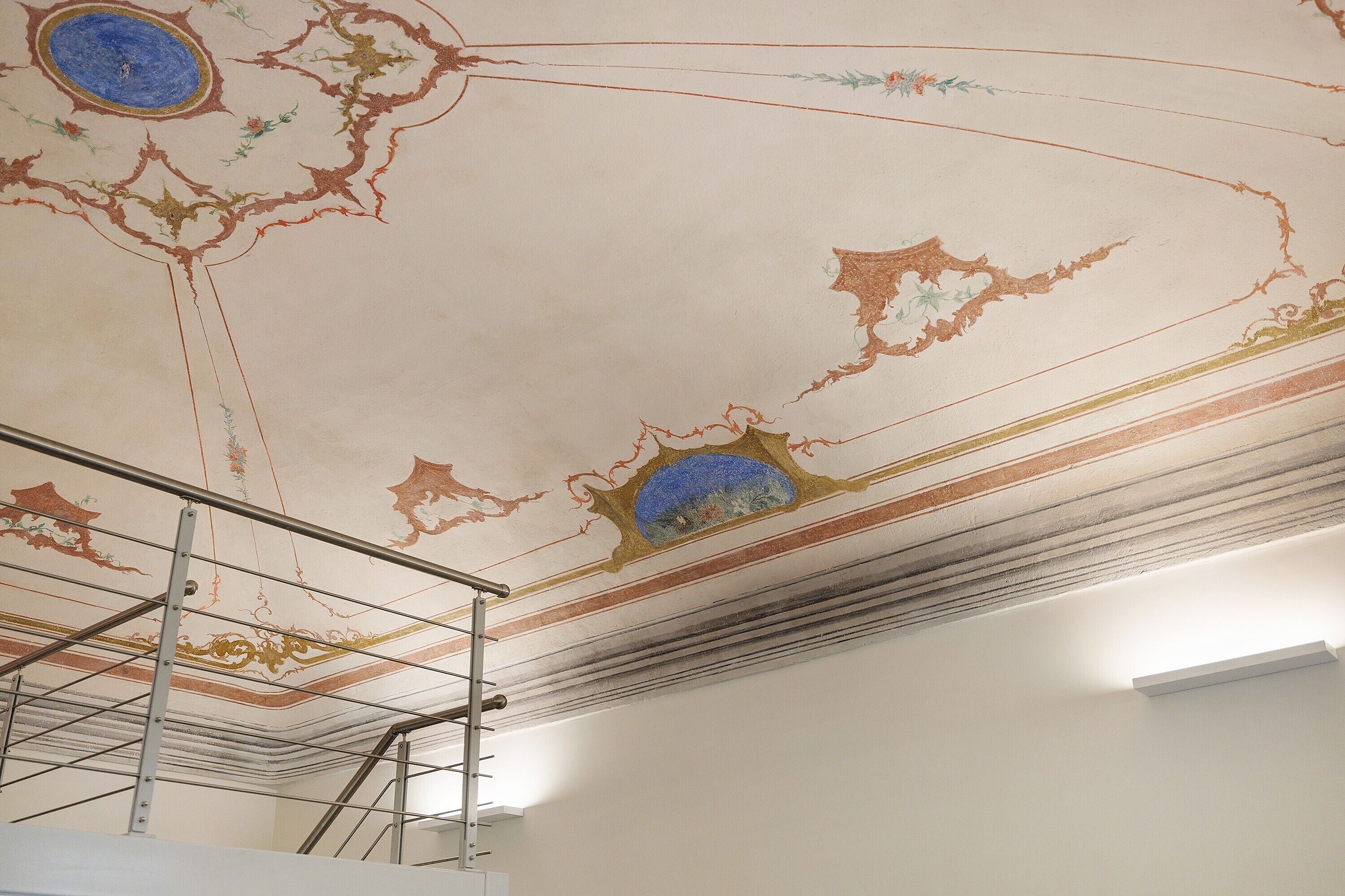 Un plafond orné de motifs complexes et une structure d’échafaudage métallique.