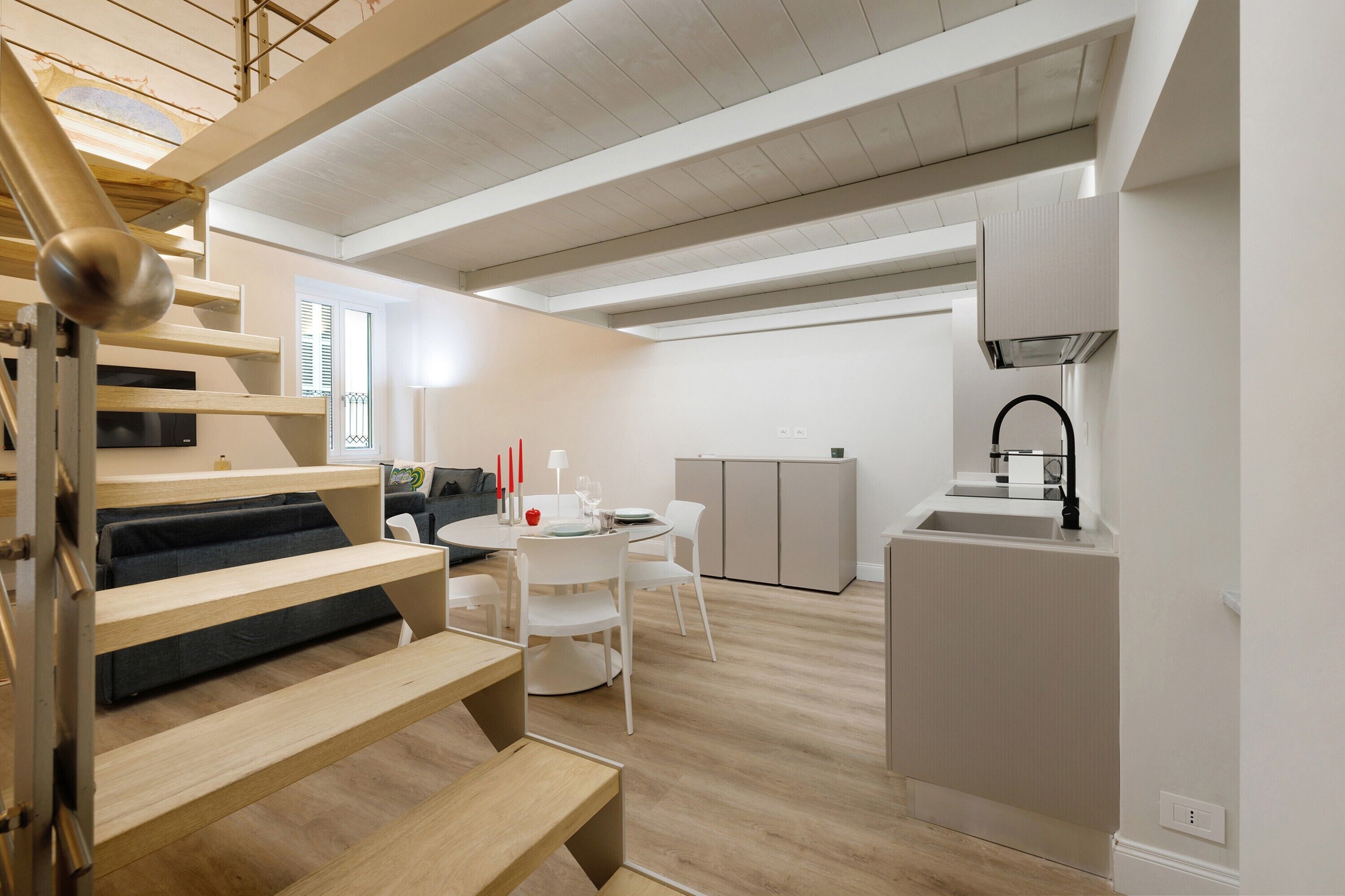 Un intérieur moderne comprenant un escalier, un coin repas et une cuisine.