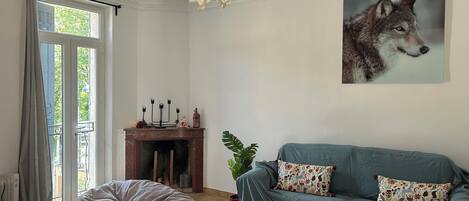 Ein Wohnzimmer mit einer Couch, einem Sitzsack, einem Kamin und einem Gemälde eines Wolfs.