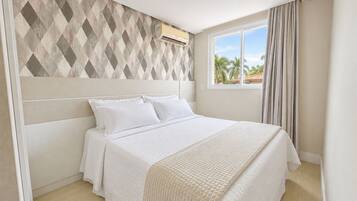 A bedroom with a bed, a window, and a wall-mounted air conditioner.