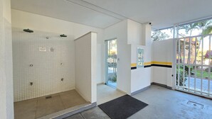 Un bagno d'hotel con zona doccia in ceramica, ingresso con porta in vetro e vista sull'esterno.