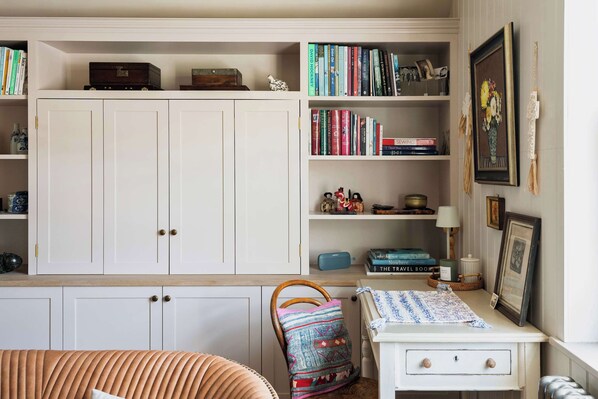 A room with a large white wardrobe, a small white table with a lamp, and a chair with a colorful cushion. - Stylish Sydney Wharf | Free Parking | Sleeps 4 (Bath)