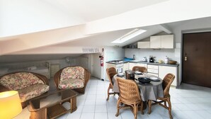 Un espace de vie compact comprenant un coin repas, une kitchenette et un canapé.