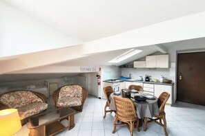 Un espai habitable reduït amb zona de menjador, petita cuina i sofà.