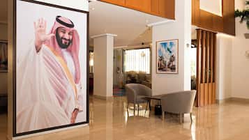 A lobby with a large portrait, a seating area, and a wooden partition.