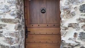 Une porte en bois avec une poignée en métal, encastrée dans un mur de pierre.