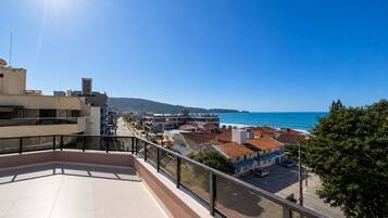 A rooftop terrace with a clear view of the sea and buildings.