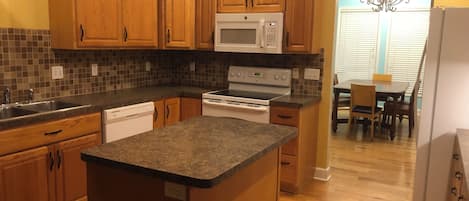 A kitchen with wooden cabinets, a microwave, an oven, and a dishwasher.