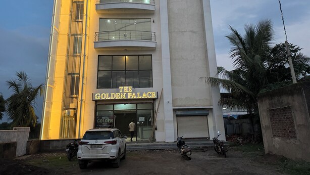 Ein Hotel namens 'The Golden Palace' mit modernem Design, das mehrere Etagen und einen markanten Eingang aufweist.