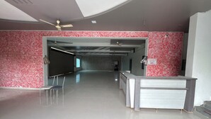 Eine geräumige Lobby mit einer Rezeption, einem Deckenventilator und Wandverkleidung mit Muster.