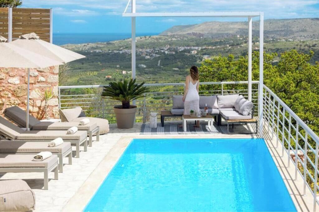 A poolside area with lounge chairs and a view of the landscape.