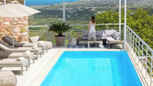 A poolside area with lounge chairs and a view of the landscape. - Dream View Villa Kastellos (Kastellos)