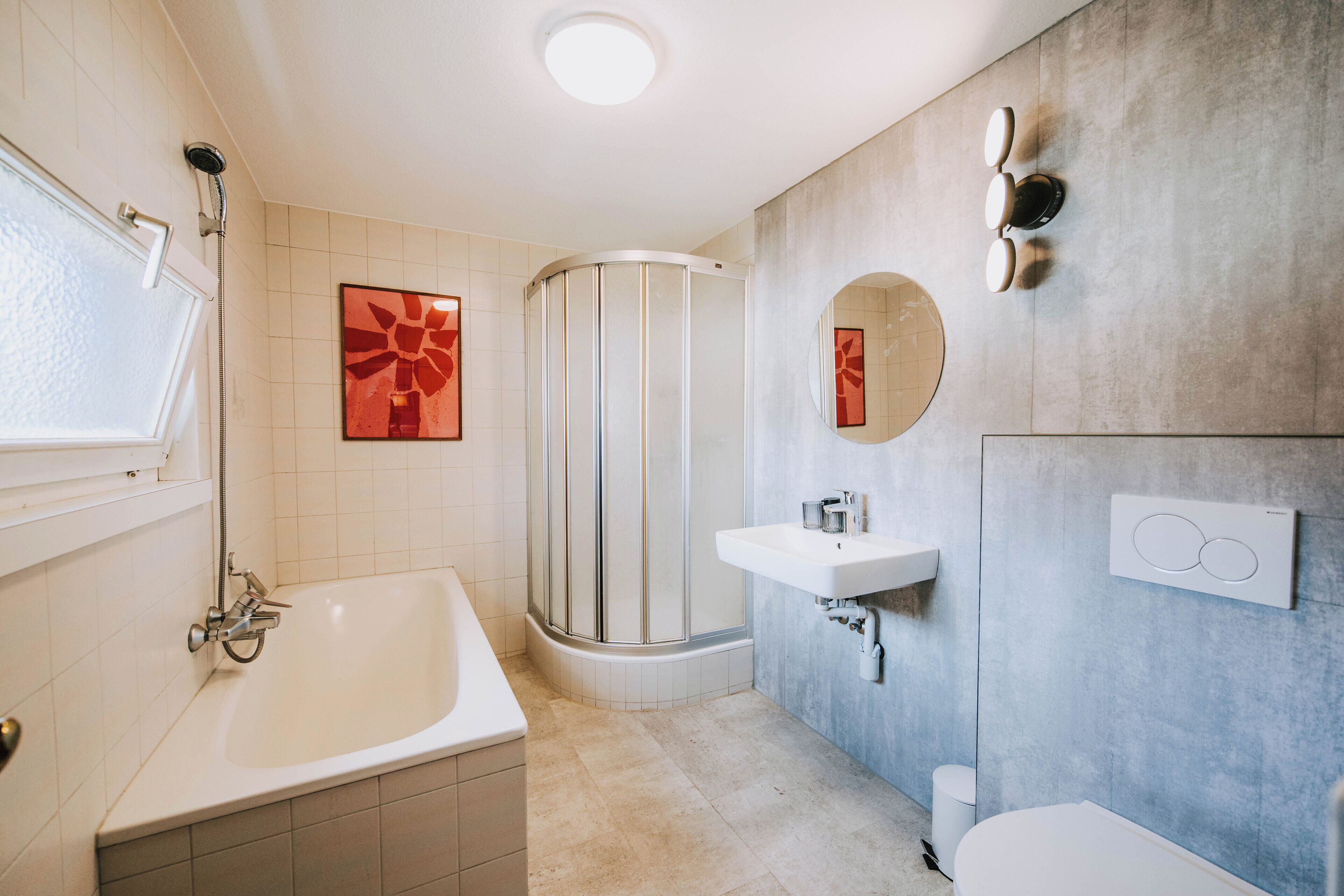 A modern bathroom with a bathtub, a shower, a sink, and a toilet.