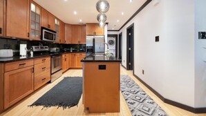 A modern kitchen with wooden cabinets, stainless steel appliances, and a central island. - 301-4thstreet-318 (Austin)