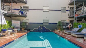 A pool area with a sign indicating no lifeguard on duty, lounge chairs, and a tiled pool edge. - 301-4thstreet-318 (Austin)
