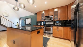Una cocina moderna con armarios de madera, electrodomésticos de acero inoxidable y una isla central.