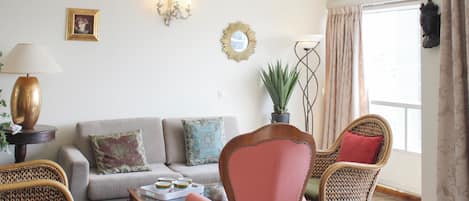 A living room with a sofa, two armchairs, a coffee table, and a lamp.