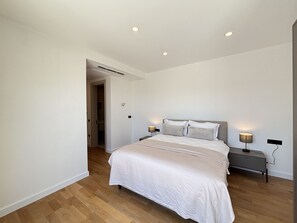 Une chambre à coucher avec un lit, des tables de chevet et une commode.
