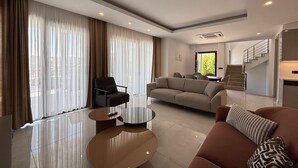 A modern living room with a sofa, armchairs, and a coffee table.