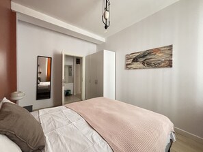 A bedroom with a bed, a wardrobe, a mirror, and a painting on the wall. - Comfortable 2BR | Walk to Sultanahmet (Istanbul)